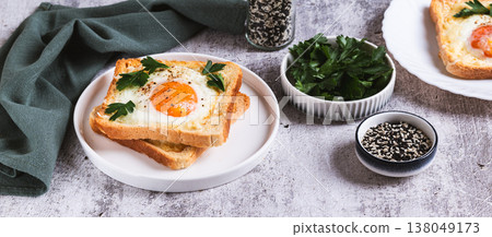 An egg baked in pieces of bread on a plate on the table web banner 138049173