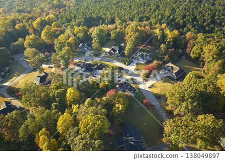 View from above of expensive residential houses between yellow fall trees in suburban area in South Carolina. American dream homes as example of real estate development in US suburbs View from above of expensive residential houses between yellow fall trees in suburban area in South Carolina. American dream homes as example of real estate development in US suburbs 138049897