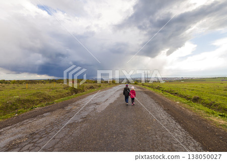 Two little children boy and girl walking on a road Two little children boy and girl walking on a road 138050027