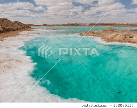 The crystal-clear turquoise blue of the Siwa Oasis salt lake and the white salt horizon. 138050135