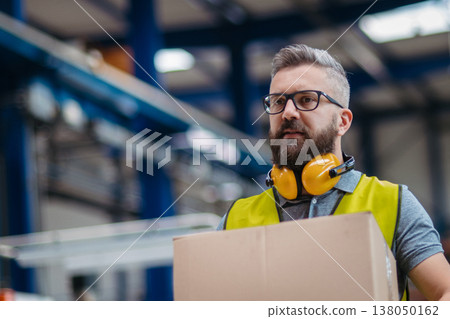 Warehouse or factory worker carrying products in box. 138050162