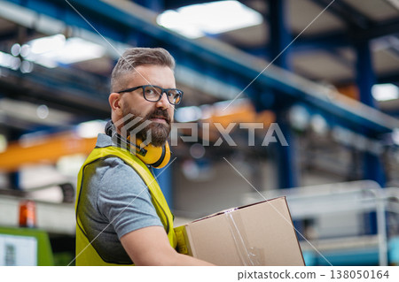 Warehouse or factory worker carrying products in box. 138050164