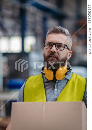 Warehouse or factory worker carrying products in box. 138050165