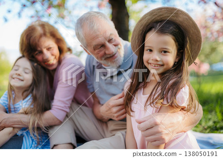 Grandparents spending time with granddaughters in park. Grandparents spending time with granddaughters in park. 138050191