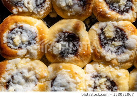 Top view of traditional czech buns filled with plum jam and topped with curd and crumble on baking tray, homemade recipe, rustic dessert, authentic sweet pastry concept Top view of traditional czech buns filled with plum jam and topped with curd and crumble on baking tray, homemade recipe, rustic dessert, authentic sweet pastry concept 138051067
