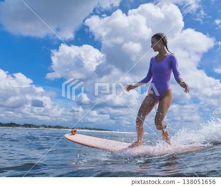Tranquil Young Woman Balancing On Longboard At Coast With Peaceful Attitude Tranquil Young Woman Balancing On Longboard At Coast With Peaceful Attitude 138051656