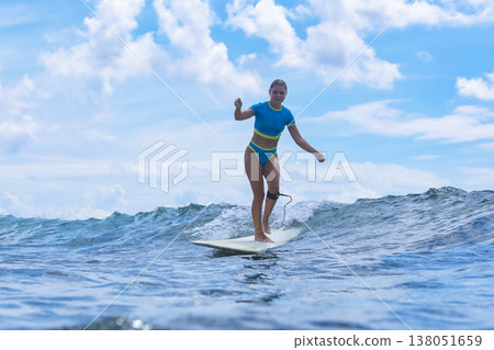 Vigorous Woman Skillfully Maneuvering Through Water Spray On Surfboard Vigorous Woman Skillfully Maneuvering Through Water Spray On Surfboard 138051659