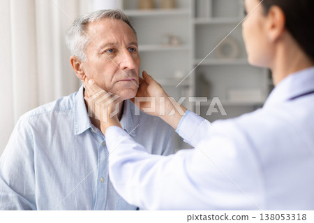 Female doctor touching lymph nodes and consulting senior male patient in clinic Female doctor touching lymph nodes and consulting senior male patient in clinic 138053318