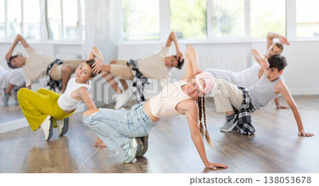 Group of young friends learn group dances - low break and breakdance in studio Group of young friends learn group dances - low break and breakdance in studio 138053678