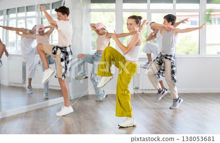 Teenage girl practicing hip hop reject step in training hall Teenage girl practicing hip hop reject step in training hall 138053681