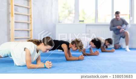 Child pupils performs plank exercises Child pupils performs plank exercises 138053683