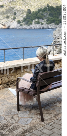 Young woman resting on a bench in a picturesque mountain gorge 138053804
