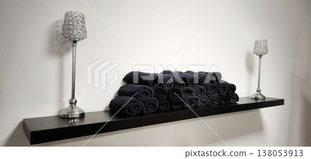 Elegant arrangement of rolled black towels in a spa Elegant arrangement of rolled black towels in a spa 138053913
