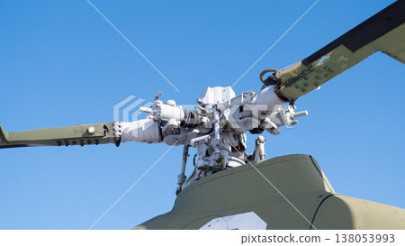 Closeup Helicopter Rotor Hub Exposed Components Against Clear Blue Sky Showing Weathered Paint, Grease And Bolts, Detailed Swashplate And Pitch Control Linkage, Visible Gearbox Elements 138053993