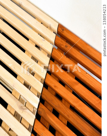 Wooden slats of two colors, lighter wood placed next to darker red brown wood. Natural decorative texture or background for modern design, furniture piece. Pattern formed by slats coming together Wooden slats of two colors, lighter wood placed next to darker red brown wood. Natural decorative texture or background for modern design, furniture piece. Pattern formed by slats coming together 138054213