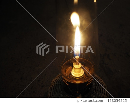 The flame of an oil lantern illuminates the campsite at night. The flame of an oil lantern illuminates the campsite at night. 138054225