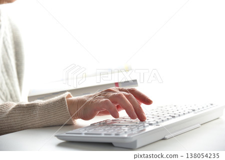 Image of a senior citizen's hands while entering data. Image of a senior citizen's hands while entering data. 138054235