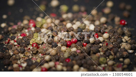 Mix of different peppercorns placed on a dark surface for culinary use in cooking and seasoning dishes at home or restaurants 138054601