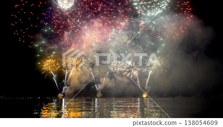 Fireworks display over water during night celebration in summer Fireworks display over water during night celebration in summer 138054609