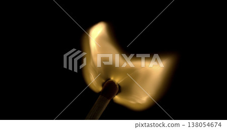 Flame burning on a matchstick held in a dark setting with smoke rising in the air Flame burning on a matchstick held in a dark setting with smoke rising in the air 138054674