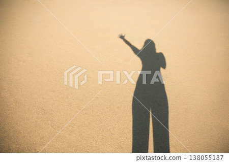 Shadow of a person waving on sandy surface of beach Shadow of a person waving on sandy surface of beach 138055187