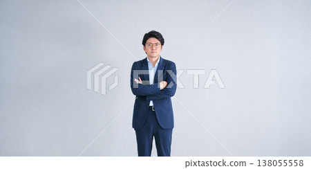 一名三十多歲的男子,身穿西裝,雙手交叉放在胸前,神情嚴肅地直視鏡頭。 一名三十多歲的男子,身穿西裝,雙手交叉放在胸前,神情嚴肅地直視鏡頭。 138055558