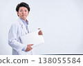 A confident and refreshing expression on the face of a male doctor in his 30s, wearing a white coat and holding a laptop under his arm, against a white background. 138055584