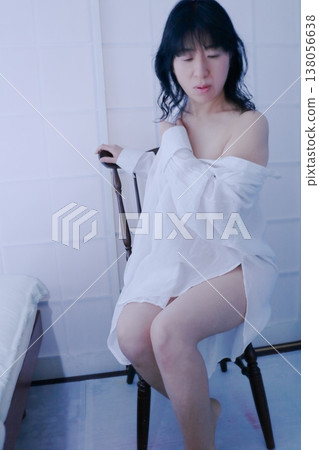 一個穿著白色洋裝坐在椅子上的女人 138056638