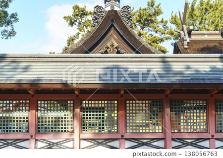 Traditional Japanese Shinto shrine architecture with green lattice screens in vermillion frames and a detailed cypress bark gabled roof. Historic cultural landmark and spiritual site in Japan. Traditional Japanese Shinto shrine architecture with green lattice screens in vermillion frames and a detailed cypress bark gabled roof. Historic cultural landmark and spiritual site in Japan. 138056763