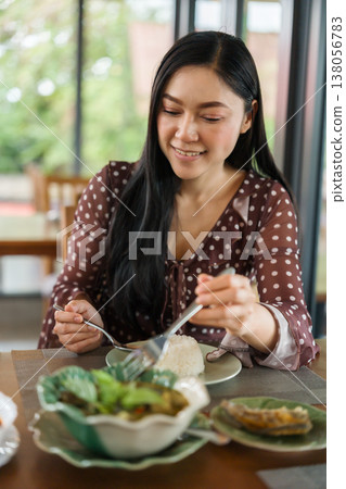 woman eating with food in restaurant 138056783