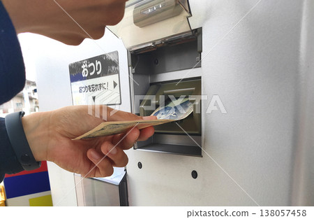 Insert a 1,000 yen bill into the change machine. Insert a 1,000 yen bill into the change machine. 138057458