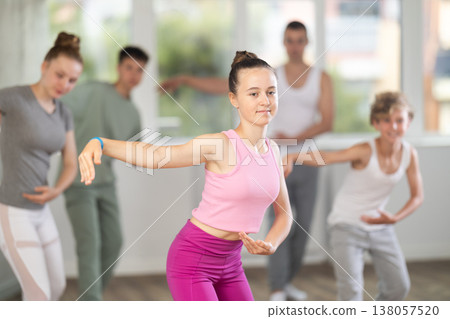 Girls and boys are learning various dance and ballet movements in studio Girls and boys are learning various dance and ballet movements in studio 138057520