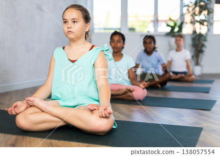 Training yoga kids on yoga mat in gym. Training yoga kids on yoga mat in gym. 138057554