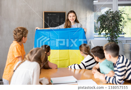 Teacher showing Ukraine flag to group of schoolchildren 138057555