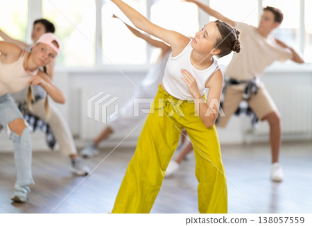 Stylishly dressed teenagers learn to dance hip-hop and breakdance in dance studio 138057559