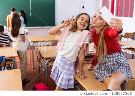 Cheerful girls classmates taking funny selfie with phone during break 138057568