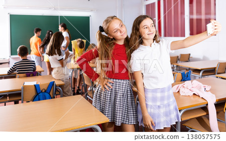 Two girls taking selfies in classroom during recess Two girls taking selfies in classroom during recess 138057575