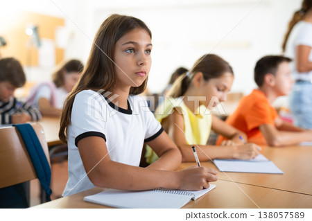 Girl studying in school during lesson 138057589