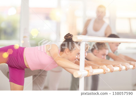 Teenagers ballet lovers learn to perform arabesque pose in choreography studio Teenagers ballet lovers learn to perform arabesque pose in choreography studio 138057590