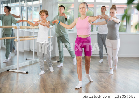 Young girl in group lesson with students rehearses, practices ballet dance, staging. Young girl in group lesson with students rehearses, practices ballet dance, staging. 138057593
