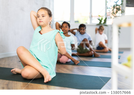 Young girl doing yoga in group of children 138057666