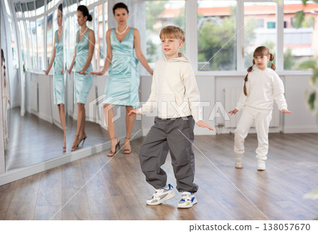 Tween boy mimicking comedic stroll of Charlie Chaplin during dance rehearsal Tween boy mimicking comedic stroll of Charlie Chaplin during dance rehearsal 138057670