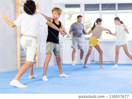 Boy and girl train to perform works out blow to jaw at opponent, while learning self-defense Boy and girl train to perform works out blow to jaw at opponent, while learning self-defense 138057677