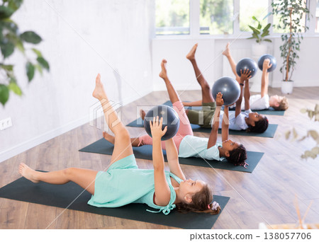 Kids doing pilates with softball Kids doing pilates with softball 138057706