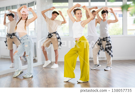 Teenagers in casual clothes are training together to dance hip-hop and breakdancing in dance center Teenagers in casual clothes are training together to dance hip-hop and breakdancing in dance center 138057735