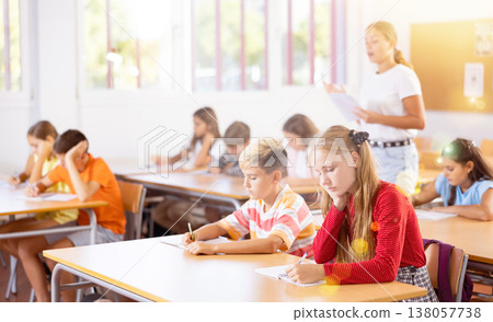 Girl and boy exercising in classroom Girl and boy exercising in classroom 138057738