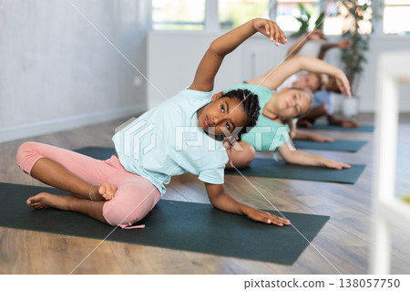 Training yoga kids on yoga mat in gym. Training yoga kids on yoga mat in gym. 138057750
