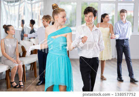 Group of couple of teenagers in evening dresses dance an polonaise dance Group of couple of teenagers in evening dresses dance an polonaise dance 138057752