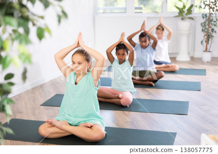 Children together making yoga meditation in lotus pose in fitness studio 138057775