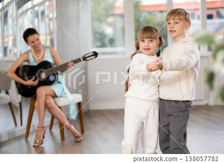 Boy and girl in pair train to dance tango during classes with accompaniment of guitar 138057782